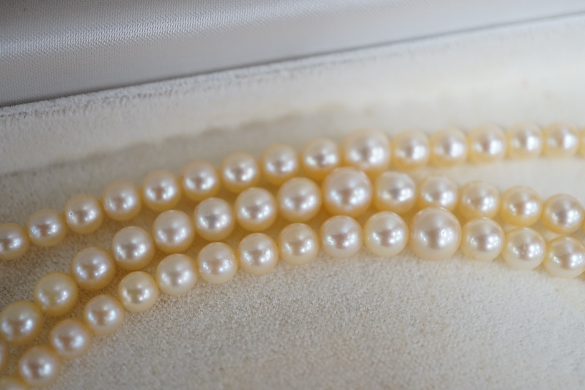 A triple strand graduated cultured pearl necklace, with marcasite set white metal clasp, 40cm. Condition - fair to good.